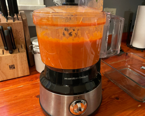 A food processor with the blended sauce mixture inside it
